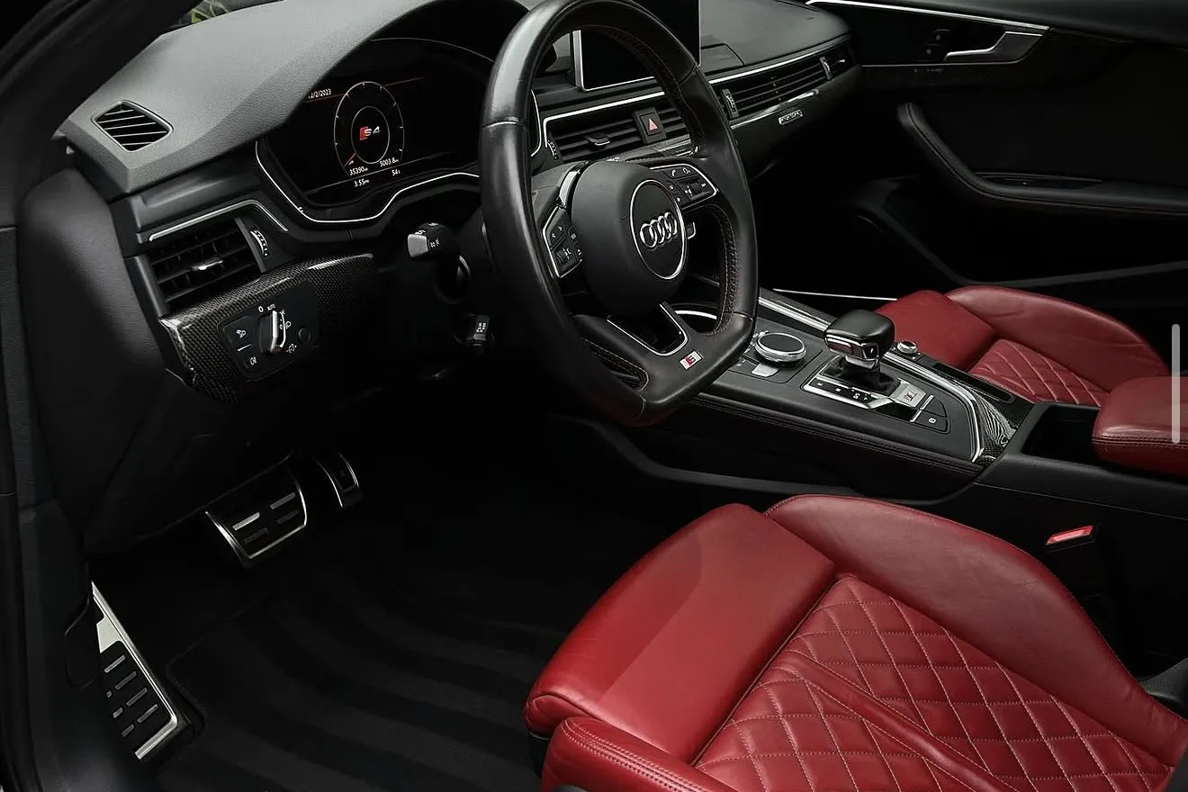The cabin of an Audi S4 with red diamond stitched leather seats and a detailed dash after a full interior detail by Auto Aesthetics near Binghamton, NY