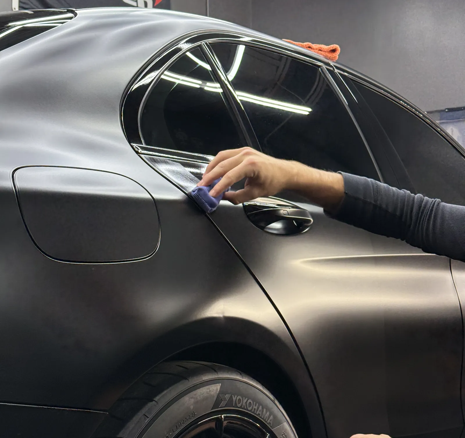 Machine paint correction refining a matte black finish with a dual action polisher during an Auto Aesthetics detail in Broome County, NY